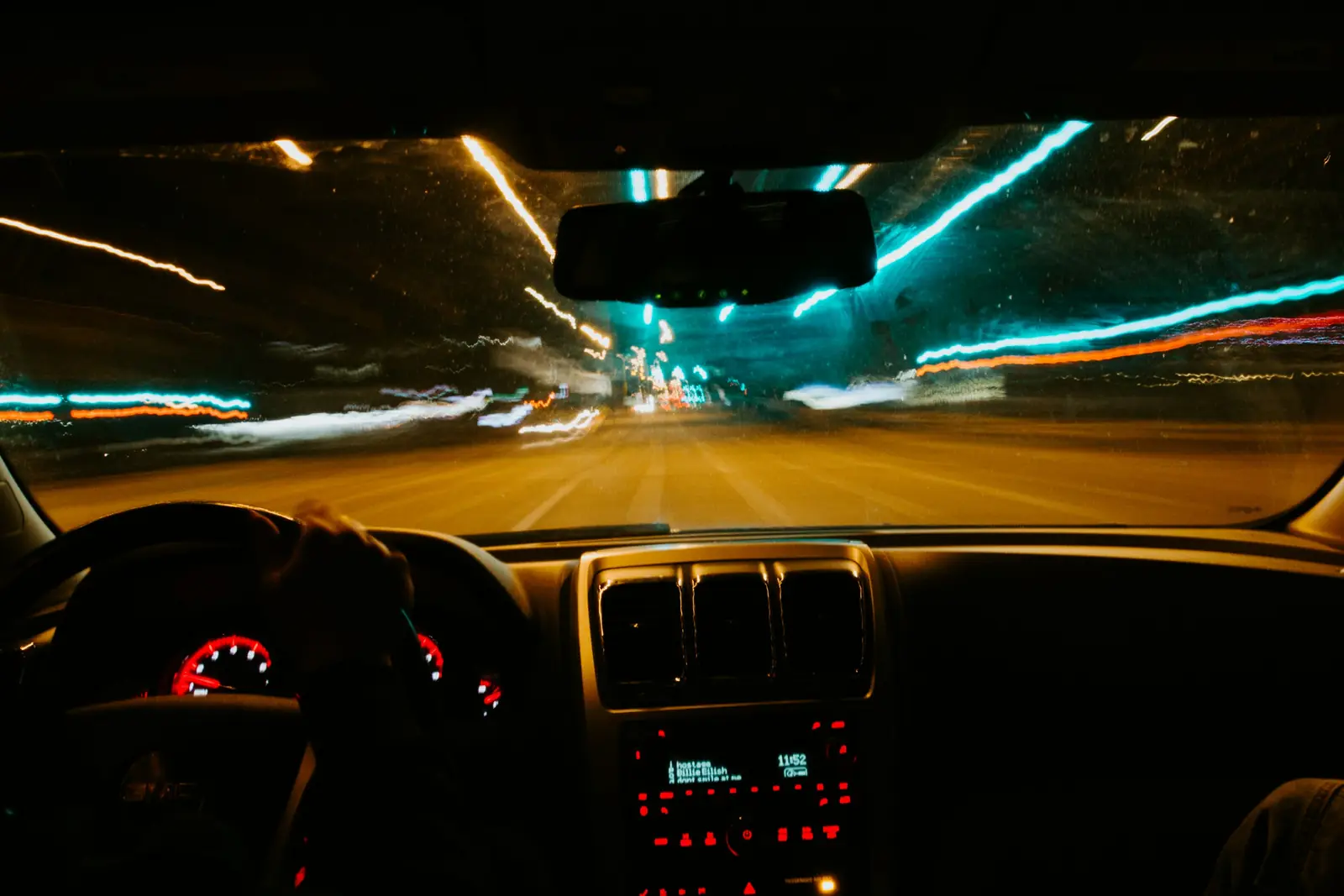 City lights at night through a car windscreen